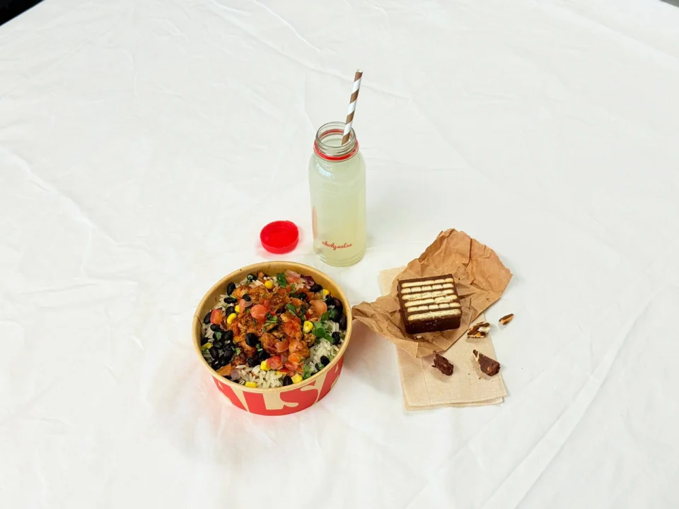 A Baby Bowl meal from Salsa Shop featuring a fresh mini burrito bowl, a cookie, and a cup of lime soda — part of the limited-time Baby Bowl deal.